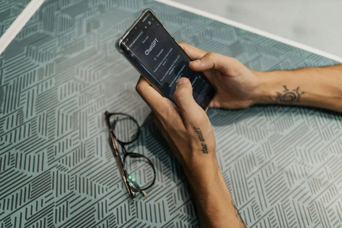 two hands holding phone with chat gpt window displayed